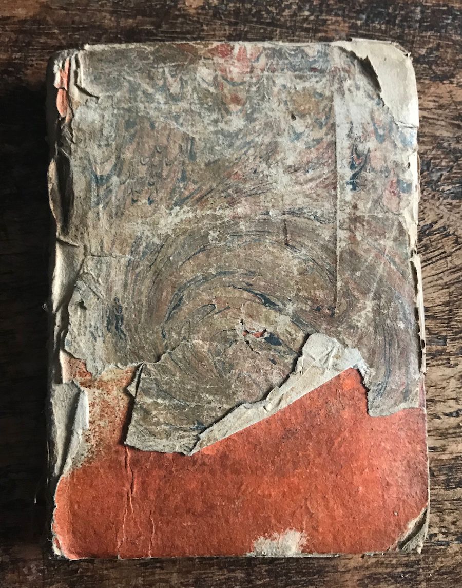 Photo of small book with damaged front cover