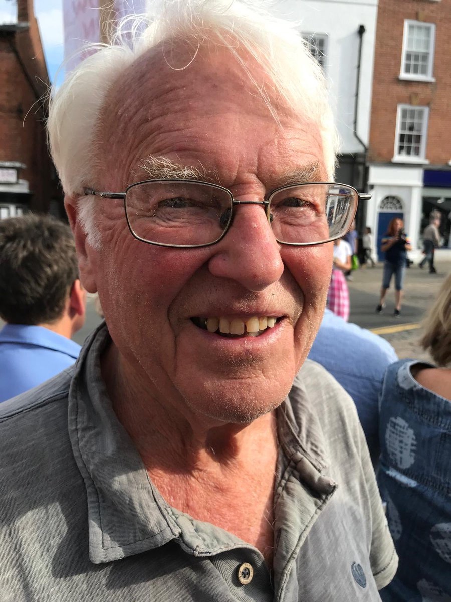 Photo of smiling man, taken in a sunny street
